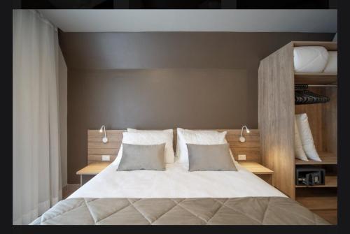 une chambre avec un grand lit avec des draps et des oreillers blancs dans l'établissement Laghetto Resort Golden Gramado, à Gramado