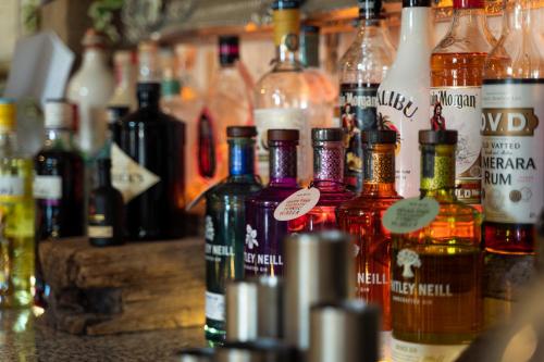 a bunch of bottles of alcohol on a bar at The Juniperlea Inn in Pathhead