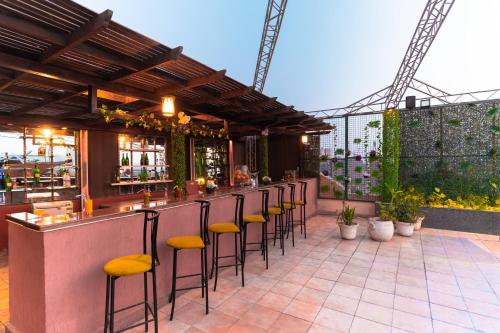 a bar with yellow stools on a patio at Swiss Inn Nile Hotel in Cairo