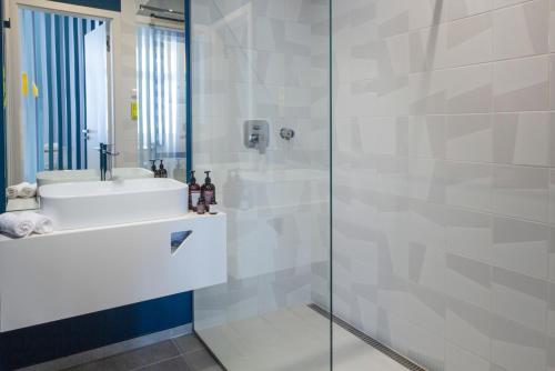 a bathroom with a sink and a glass shower at OREA Place Seno in Prague
