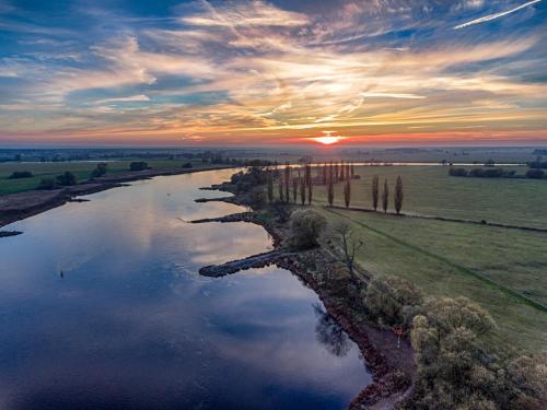 an aerial view of a river at sunset at ALTE SCHULE WITTENBERG, 3 Ferienwohnungen für bis zu 12 Personen, an der Elbe, mit Garten in Lutherstadt Wittenberg