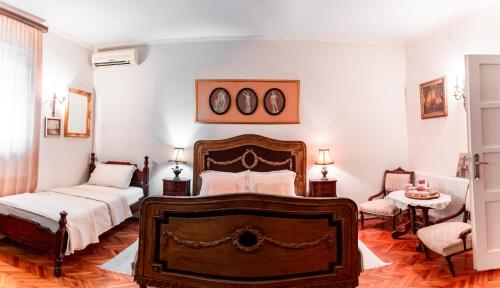 a bedroom with two beds and a table and two chairs at Vila Mila in Arandjelovac