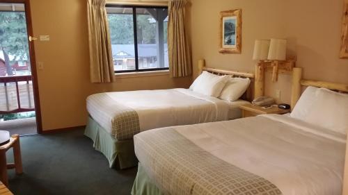 a hotel room with two beds and a window at Wildwood Inn in Twain Harte
