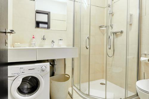 a bathroom with a washing machine and a shower at VINOHRADSKY DUM Residence in Prague