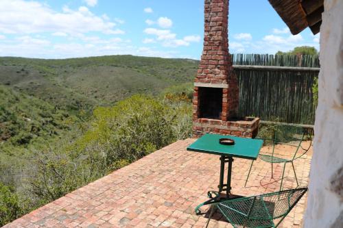 a table on a brick patio with a view of the mountains at Wild Rescue Nature Reserve in Riversdale