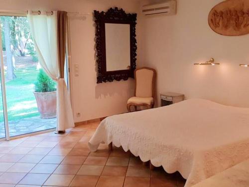 ein Schlafzimmer mit einem Bett und einem Spiegel an der Wand in der Unterkunft Villa raffinée à Orange avec piscine privée in Orange