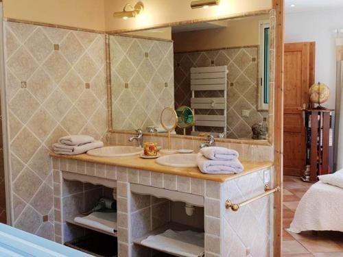 ein Badezimmer mit zwei Waschbecken und einem großen Spiegel in der Unterkunft Villa raffinée à Orange avec piscine privée in Orange