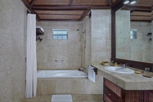y baño con bañera y lavamanos. en Hotel Tjampuhan Spa, en Ubud