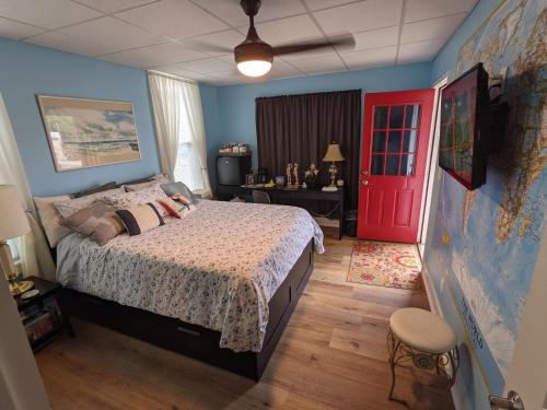 1 dormitorio con 1 cama y puerta roja en The Estate Studio in Downtown Milford, en Milford