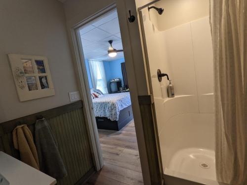 La salle de bains est pourvue d'une douche, d'une baignoire et d'un lit. dans l'établissement The Estate Studio in Downtown Milford, à Milford