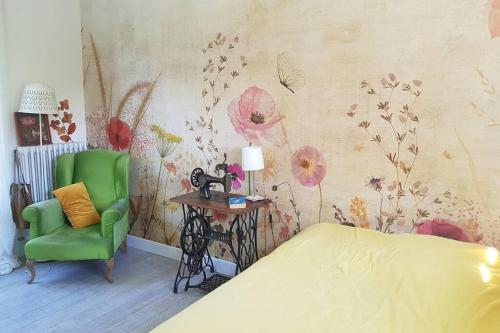 a bedroom with a bed and a green chair at Maison avec jardin à 30 minutes de Paris in Brunoy