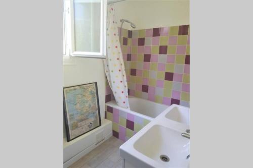 a bathroom with a sink and a colorful tile wall at Maison avec jardin à 30 minutes de Paris in Brunoy