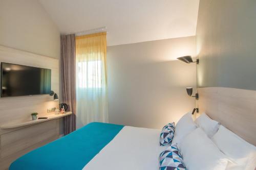 a bedroom with a white bed and white walls at Appart'City Confort Montpellier Saint Roch in Montpellier
