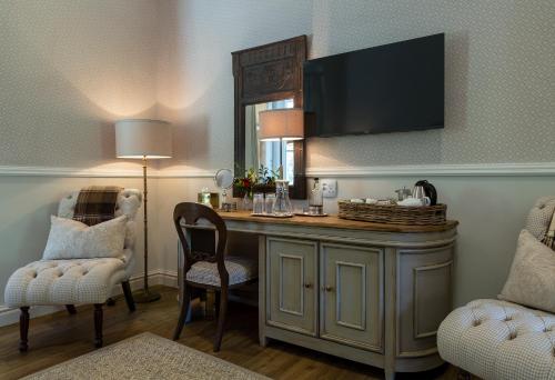 a room with a desk with two chairs and a mirror at Hartford House in Mooirivier