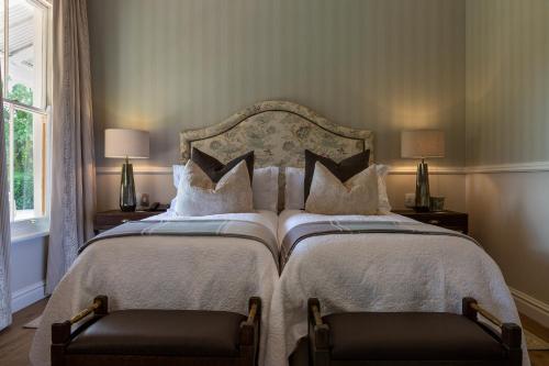 a bedroom with two beds and two chairs at Hartford House in Mooirivier