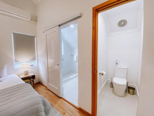 a bedroom with a bed and a glass shower door at Whitesands in Dunsborough