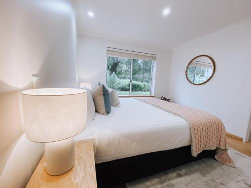 a white bedroom with a large bed and a window at Whitesands in Dunsborough