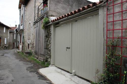 une porte de garage blanche sur le côté du bâtiment dans l'établissement La Maison Angelina, à Saint-Lizier