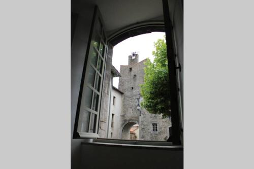 an open window with a view of a castle at La Maison Angelina in Saint-Lizier