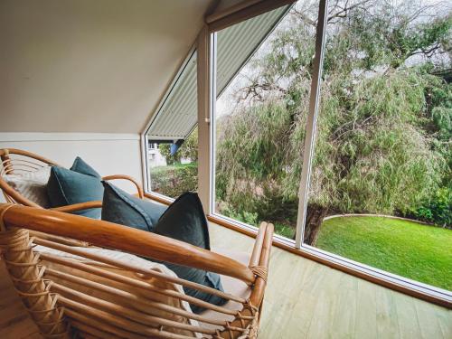 a room with wicker chairs and a large window at Whitesands in Dunsborough