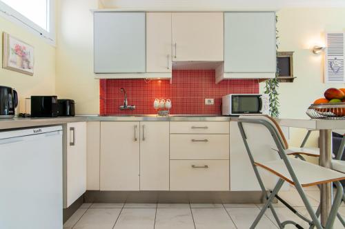 una cucina con mobili bianchi e un tavolo di El Dorado Garden View PH04 ad Arona