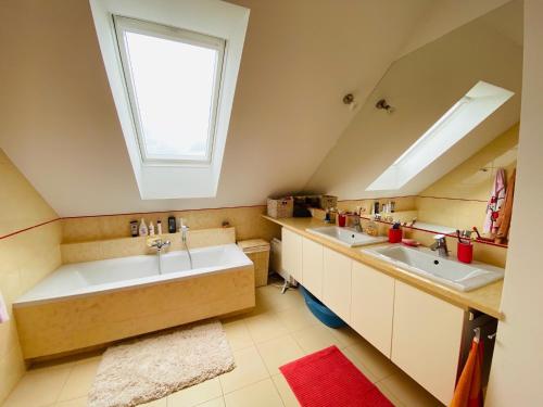 a bathroom with two sinks and a skylight at Biały Dom nad jeziorem Rajgrodzkim in Krzywe
