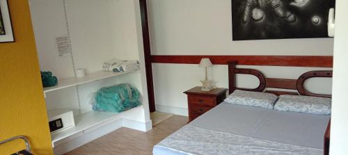 1 dormitorio con 1 cama y vestidor con espejo en Loft beira-mar Piratininga Niterói RJ en Niterói