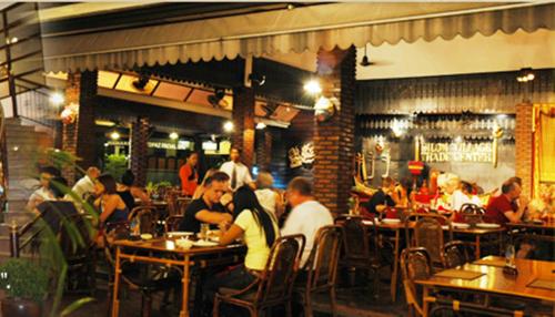 a group of people sitting at tables in a restaurant at Silom Village Inn in Bangkok