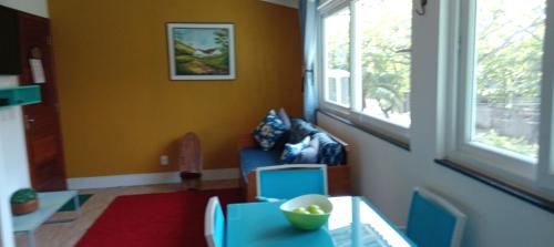 a living room with a blue chair and a table at Loft Beira Mar Piratininga Niterói RJ in Niterói