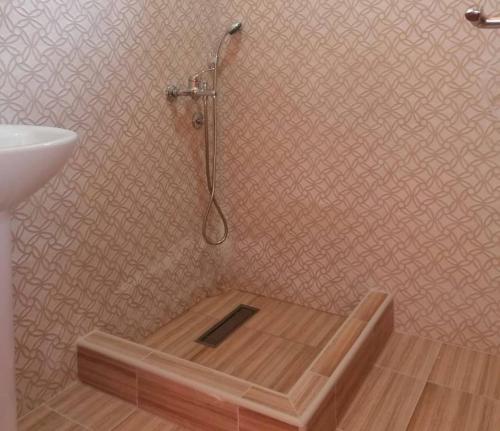 a shower with a wooden floor in a bathroom at Log cabin 2 Merdovic in Mojkovac
