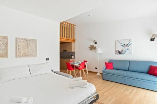 a bedroom with a bed and a blue couch at Gressoney Saint-Jean apartments by Halldis in Gressoney-Saint-Jean