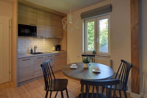- une cuisine avec une table et des chaises en bois dans l'établissement Apartamenty Sun Seasons 24 - Willa Karpacz, à Karpacz