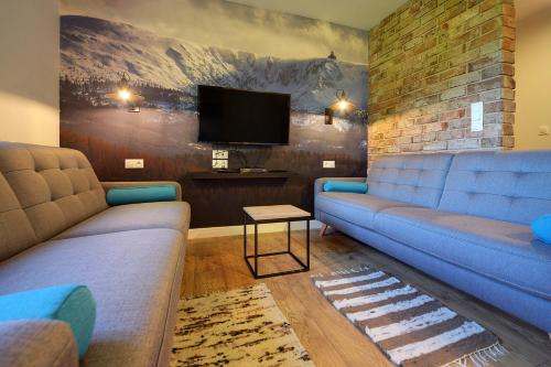 - un salon avec deux canapés et une télévision à écran plat dans l'établissement Apartamenty Sun Seasons 24 - Willa Karpacz, à Karpacz