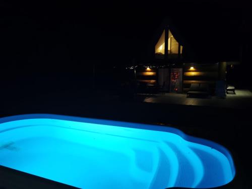 a blue light in front of a church at night at Całoroczny dom na Mazurach WrzoSPA z jacuzzi in Stare Juchy