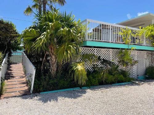 a house with a balcony and a palm tree at Gulf View Waterfront Resort in Marathon
