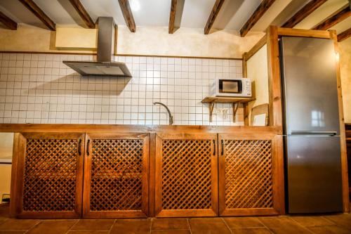 a kitchen with a stainless steel refrigerator and a microwave at Casa rural El Veredero in Castrojeriz