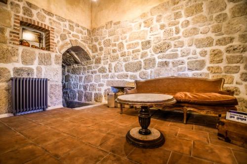 a room with a couch and a table in a stone wall at Casa rural El Veredero in Castrojeriz