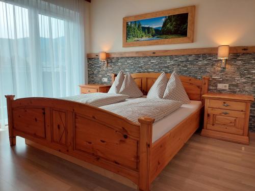 a bedroom with a wooden bed and a brick wall at Appartements Zauchenseeblick Thunhart in Altenmarkt im Pongau