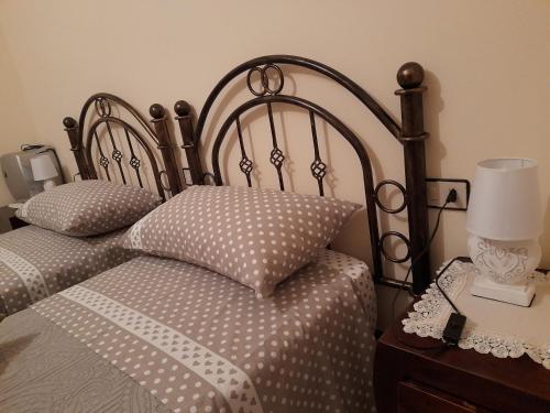 a bedroom with two beds and a table with a lamp at Locanda 130 in Fonni