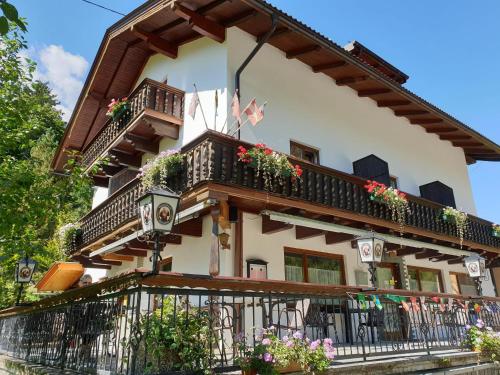 a building with a balcony with flowers on it at Tattoo PENSION mit Restaurant und Tattoo-Studio in Mörtschach