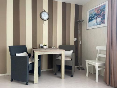 Habitación con mesa, sillas y reloj en De Spiegel en Schagen