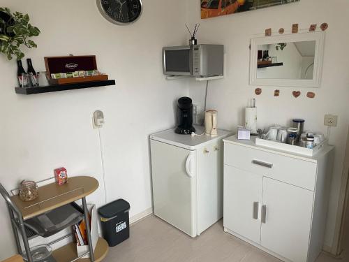een keuken met een witte koelkast en een tafel bij De Spiegel in Schagen