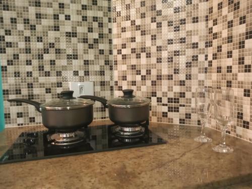 two pots on top of a stove in a kitchen at Chalé de Charme Mandomai in Ilhabela