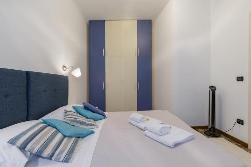 Una cama con almohadas azules y blancas. en SUITE CRISTINA en Verona
