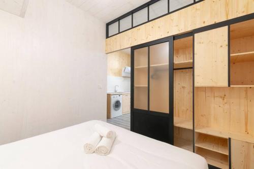 1 dormitorio con cama, paredes de madera y armario en Le Trésor des Soeurs Macarons, en Nancy