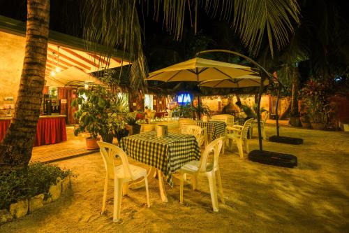 a restaurant with tables and chairs and an umbrella at Shallow Lagoon Rasdhoo in Rasdu