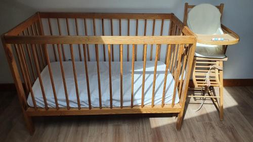 a wooden crib with a chair in a room at cellier 1 in Les Deux Alpes
