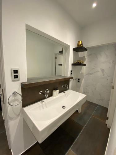 une salle de bain avec un lavabo blanc et un miroir dans l'établissement Viet Anh appartement, à Blankenberge