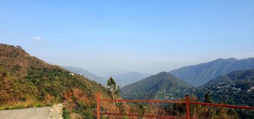 a red fence on the side of a mountain at Karinya Villas in Nainital