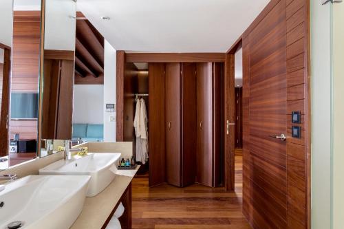 a bathroom with two sinks and a wooden door at Horizon Blu Boutique Hotel in Kalamata